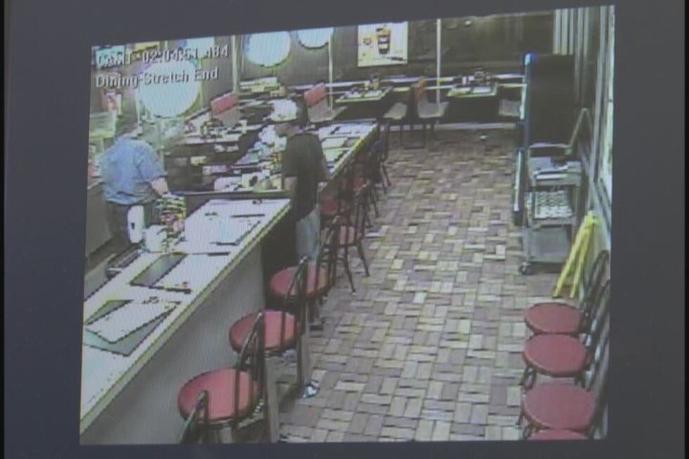 Surveillance video of the 18-25 year-old suspect in front of the cash register moments before...