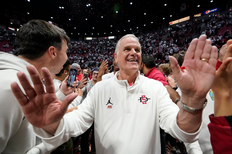 FILE - San Diego State head coach Brian Dutcher reacts with fans after San Diego State...
